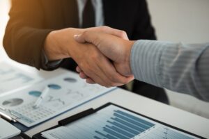 Business partnership shaking hands for signing company financial