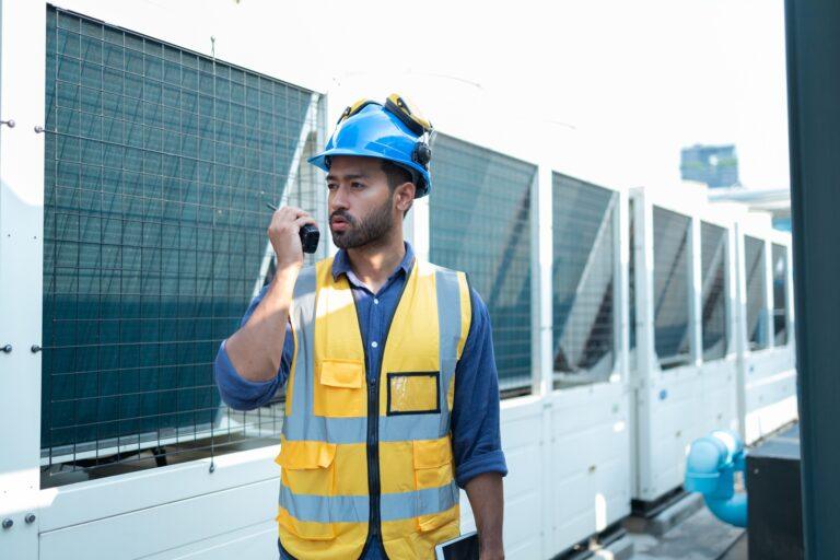 Technician Operating Control Panel in Industrial Setting