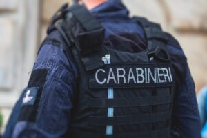 Italian Carabinieri, national gendarmerie of Italy squad,  of Italy patrol formation back view with "Carabiners" logo emblem on uniform maintain public order in the streets of Florence, Tuscany, Italy